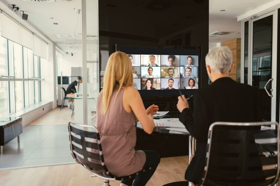 Two people videoconferencing in a huddle space.