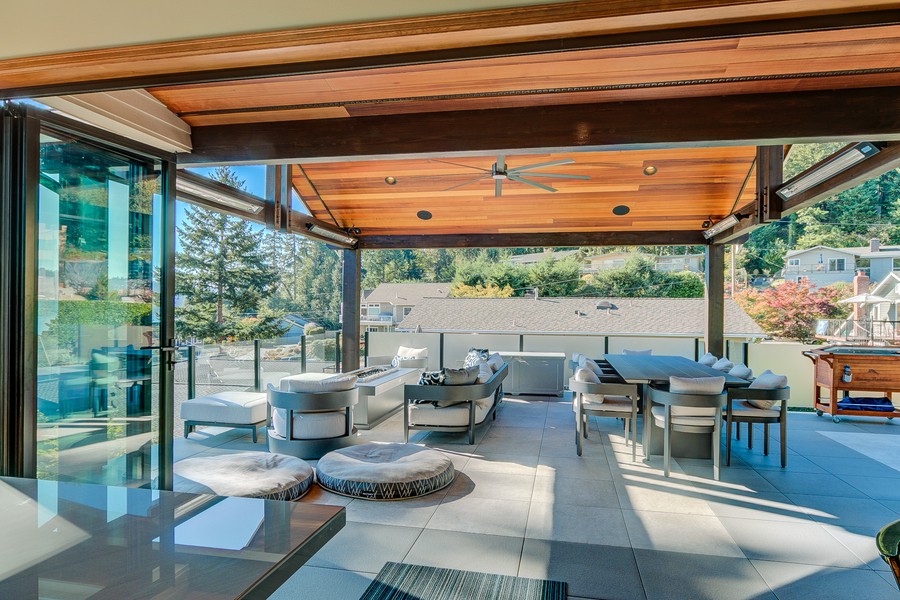 A covered outdoor patio with a wooden roof and in-ceiling speakers.