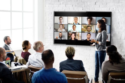 Group of people participating in a call over a video conferencing system.