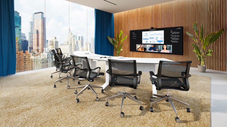 A modern conference room with a video display and city view outside the window.