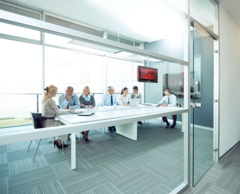 People in a meeting room using conference room AV technology. 