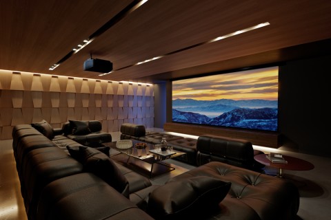 A luxury home theater with a mountain scene on the screen.