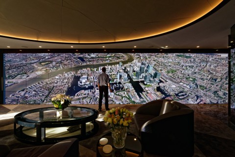 An LED video wall displaying a cityscape with a person standing in front of it.