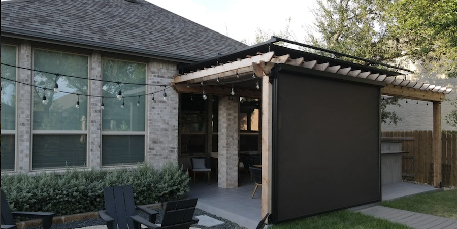 A Texas home with Draper outdoor shades lowered on a roofed patio.