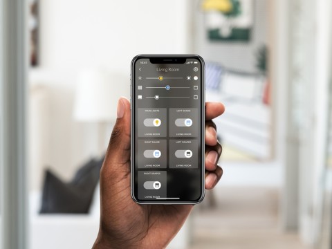 Hand holding a smart phone displaying the Josh.ai home automation system. 