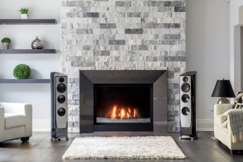 A listening room with vinyl records on a shelf and two floorstanding loudspeakers.