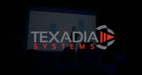 Text that reads ‘Texadia Systems’ laid over an image of a person presenting on a projector screen. 