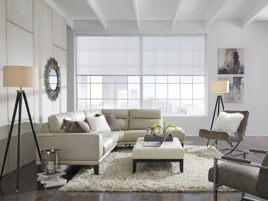 A living room with Lutron shading lowered on windows. 