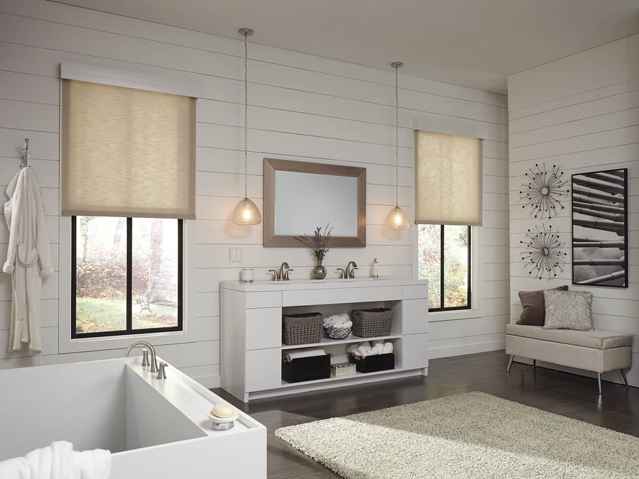 A bright, white bathroom with Lutron motorized shades lowered halfway on windows. 