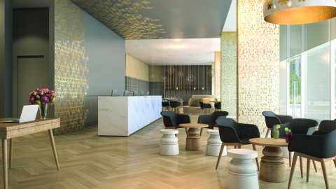 A modern hotel lobby with seating and a reception desk. 