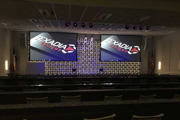 A photograph capturing a contemporary interior space with modern architectural elements, including exposed beams and large windows that flood the area with natural light.